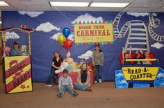 children are posing in front of a carnival display