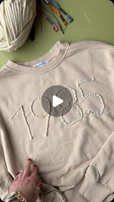 someone is making a sweater with the word joy on it