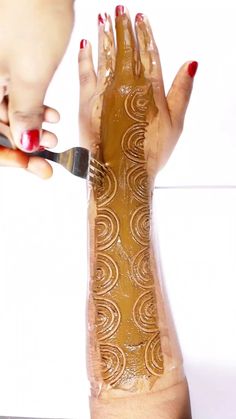 a woman is painting her arm with gold paint