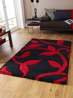 a black and red rug in a living room with wood flooring on the side