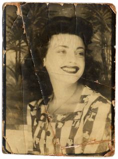 an old black and white photo of a woman with a smile on it's face