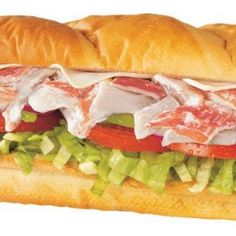 a sub sandwich with meat, lettuce and tomato slices on it's side