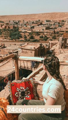 a woman sitting on top of a wooden bench