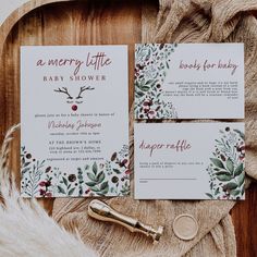 the wedding stationery is laid out on a wooden tray