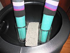 two pairs of colorful socks sitting on top of a trash can