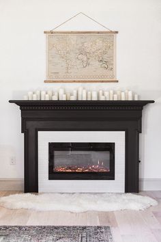 a fireplace with candles on the mantle and a map above it