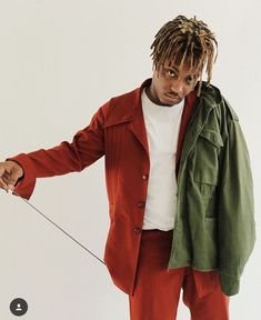 a man with dreadlocks is pulling something on a string while wearing an orange suit