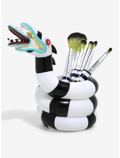 a black and white snake cup with brushes in it