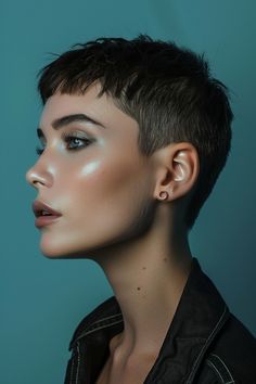 Person with a short, stylish haircut and glowing skin looking to the side against a blue background. Very Short Hair Braids, Ultra Short Hairstyles For Women, Super Short Hairstyles For Women, Buzzcuts For Women, Extra Short Hairstyle Women, Pixie With Short Bangs, Short Asymmetrical Pixie, Very Short Hairstyle Women, Cropped Pixie Haircut