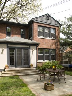 a house with a patio and table in the front yard