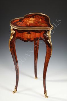 an ornately decorated wooden table with gold trimmings and flowers on the top