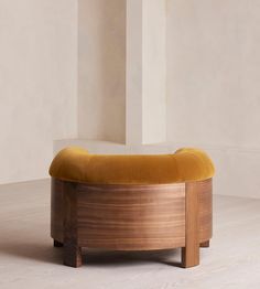 a wooden bench sitting on top of a hard wood floor next to a white wall