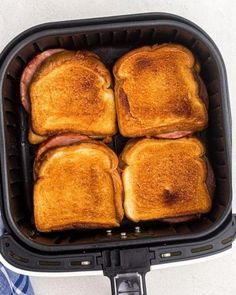 four toasted sandwiches sitting in an air fryer