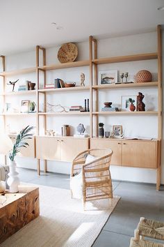 a living room filled with furniture and bookshelves next to a wall mounted shelf