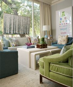 a living room filled with furniture and lots of windows covered in curtained drapes