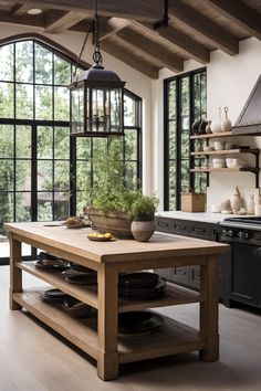 a table with plates on it in a kitchen next to an oven and windows that look out onto the woods