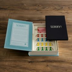 an open box containing several toothbrushes on a wooden table next to a book