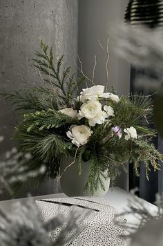 a vase filled with white flowers sitting on top of a table