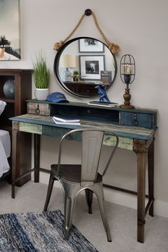 a desk with a mirror, chair and lamp in a room that has carpet on the floor