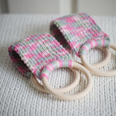 two knitted baby toys sitting on top of a white blanket covered floor next to each other