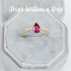 a pink tourmaline stone ring sitting on top of a velvet box with the words ships within a day written above it