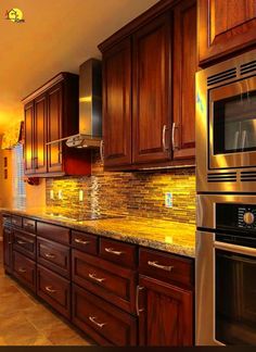 a kitchen with wooden cabinets and granite counter tops, stainless steel appliances and an oven