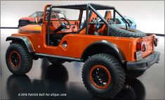 an orange jeep is parked in a showroom