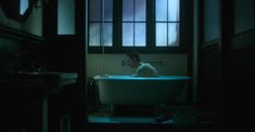 a man sitting in a bathtub with the light on