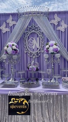 there are many silver vases on the table with flowers in them, and one is holding a monogram