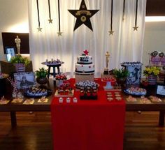 a red table topped with lots of cakes and desserts