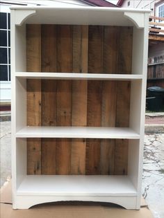 a white book shelf sitting on top of a wooden floor