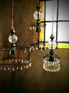 three chandeliers hanging from the ceiling next to a window