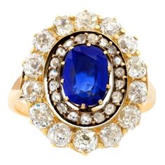 An English Antique 15 karat gold/silver top ring with sapphire and diamonds. The ring has a no heat oval-cut sapphire with an approximate weight of .95 carat, 14 old mine-cut diamonds with an approximate total weight of 1.40 carats, and 19 rose-cut diamonds with an approximate total weight of .19 carat. Designed in a classic oval cluster motif. Circa 1880. Size: 6-1/4; this ring can be sized. (MG #15469) Sapphire Antique Ring, Yellow Gold Sapphire Ring, Cheap Engagement Rings, Oval Diamond Ring, Silver Diamond Ring, Sapphire Rings, Real Gold Jewelry, Silver Top, Fine Diamond Jewelry