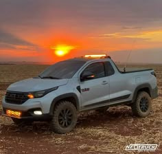 a silver truck parked on top of a dry grass field