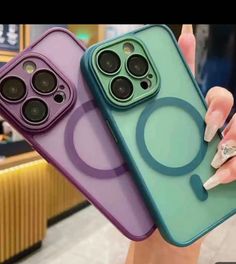 two cell phones with different colored cases on display in a store, one is purple and the other is green