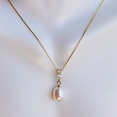 This 18K gold plated .925 sterling silver natural pearl pendant necklace is a statement of minimal elegance. Accented with lab create diamonds, it has just a touch of sparkle. 18" long box chain + 2" extender 3 cubic zirconia lab created diamonds on the bail 8mm natural freshwater pearl pendant pendant 20mm ( 3/4") long Necklace Metal: 18K gold plated 925 Sterling Silver Closure: Spring Ring imported for the best possible price This product has been curated by Tammy to complement our handmade co Gift Pearl Drop Necklace With Cubic Zirconia, Cubic Zirconia Pearl Drop Necklace As Gift, Elegant Oval Pendant Necklace With Box Chain, Elegant Diamond White Jewelry With Box Chain, Elegant Box Chain Necklace Gift For Her, Pearl Pendant Necklace With Diamond Accents For Gift, Classic Pearl Necklace With Diamond Accents As A Gift, Classic Pearl Necklace With Diamond Accents For Gift, Natural Pearl