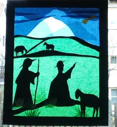 a stained glass window with silhouettes of people and animals