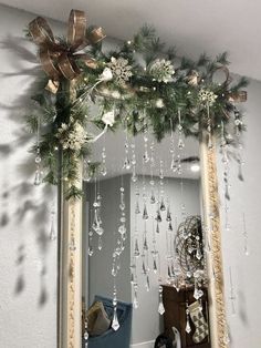 a mirror decorated with christmas decorations and hanging from it's sides in a room