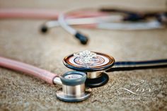 a stethoscope laying on the ground next to a pair of ear buds