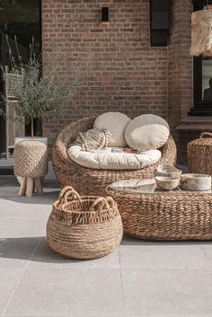 wicker furniture on the sidewalk in front of a brick building