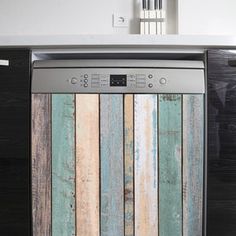 a dishwasher that is sitting in the middle of a kitchen with wood panels on it