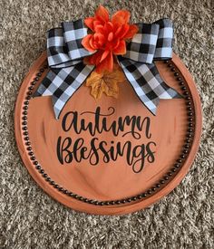 a wooden sign that says, autumn blessings on it with an orange and black bow