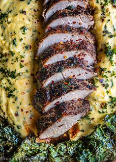 sliced meat on top of mashed potatoes and spinach with parsley sprinkles