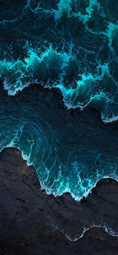 an aerial view of the ocean with waves crashing on it's shore and dark blue water