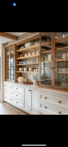 a kitchen with white cabinets and wooden shelves