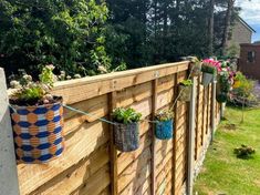 a wooden fence with hanging planters on it and the words how to build a wood fence