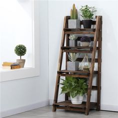 a wooden shelf filled with potted plants next to a window