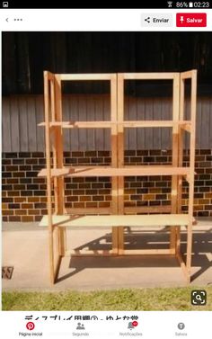 a wooden shelf sitting on top of a sidewalk next to a brick wall in front of a building