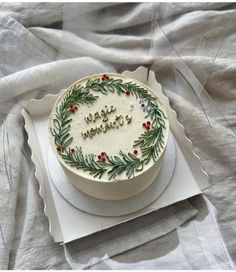 a decorated cake sitting on top of a white plate next to a cloth covered tablecloth