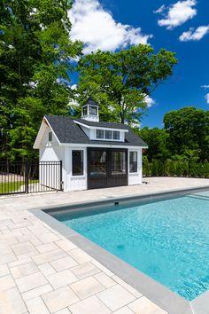 a small pool house next to a swimming pool